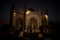 Taliban fighters walk at the entrance of the Eidgah Mosque after an explosion in Kabul