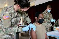 A medic administers a vaccination against COVID-19.