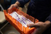 Covid-19 vaccine syringes are transported aboard the USS Kearsarge