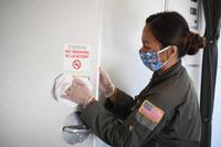 Flight attendant cleans aircraft lavatory after a mission