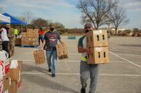 Food bank volunteers move boxes full of food and produce