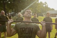 A Marine performs shoulder presses.