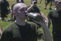 A Marine recruit hydrates after a physical training session.