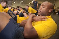 A sailor performs a sit-up during a physical readiness test.