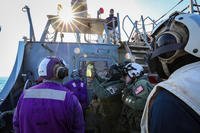 Sailors assigned to the Arleigh Burke-class guided-missile destroyer USS The Sullivans and to the ‘Ghost Riders’ of Helicopter Sea Combat Squadron (HSC) 28 check a fuel sample on the flight deck.