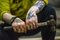 Aviation Boatswain’s Mate (Handling) 3rd Class (AW/SW) Sarah Atiyyat, from Edison, New Jersey, poses for a photo in the hangar bay of the Navy’s only forward-deployed aircraft carrier USS Ronald Reagan (CVN 76). Atiyyat is one of many sailors who has dedicated time and skin to the artwork of tattoos. (Mass Communication Specialist 3rd Class Ryan McFarlane/U.S. Navy photo)