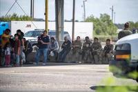 Texas National guard members with people apprehended crossing the border.