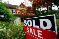 A sale sign stands outside a home.