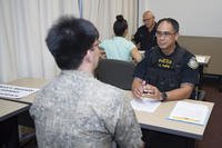 Kenneth Taipin, police captain at Joint Base Pearl Harbor-Hickam (JBPHH), interviews a potential candidate during a job fair for security guard positions held at the Federal Fire Department.