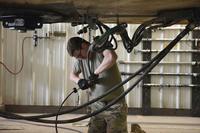 A U.S. Air Force missile handling technician connects two cords during preparation of a missile roll transfer April 20, 2021 at the missile handling facility on Malmstrom Air Force Base, Montana. (U.S. Air Force photo by Airman Elijah Van Zandt) A U.S. Air Force missile handling technician.
