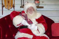 A man portraying Santa poses for photos with a 2-week-old baby at the Westfield Garden State Plaza in Paramus, New Jersey.