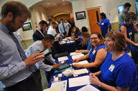 Job candidates check in with Naval Surface Warfare Center Dahlgren Division representatives at a job fair in Virginia.