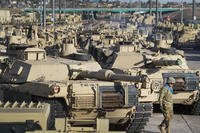 A soldier walks past a line of M1 Abrams tanks, Nov. 29, 2016, at Fort Carson