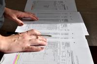 a closeup of hands of someone looking over several sheets of a checklist