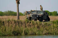 Members of the National Guard stand near a vehicle along the U.S.-Mexico border in Mission, Texas.