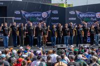 Army recruits take the Oath of Enlistment on stage at a racing event
