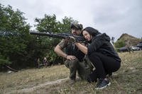 A woman fires an AK-47 during a tactical training for civilians near Zaporizhzhia, Ukraine
