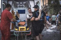 people carry a wounded person from a damaged building after Russian missile strikes in Pokrovsk