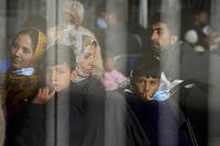 Evacuees from Afghanistan wait with other evacuees to fly to the United States