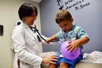 Doctor listens with stethoscope on two-year-old patient