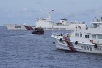 Philippine supply boat, center, maneuvers around Chinese coast guard ships