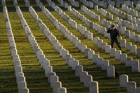 A man salutes after placing a wreath at Arlington National Cemetery.