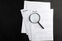 Magnifying glass on a resume.