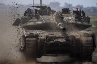 Israeli soldiers drive a tank on the border with Gaza Strip