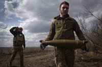 Ukrainian soldiers carry shells to fire at Russian positions