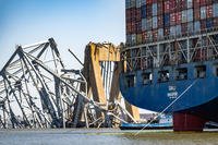The wreckage of the Francis Scott Key Bridge is seen beyond the stern of the container ship Dali