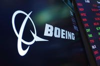 logo for Boeing appears on a screen above a trading post on the floor of the New York Stock Exchange