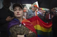 A woman soldier wrapped in the LGBT flag attends a Pride march in Kyiv, Ukraine
