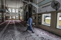 A Palestinian inspects a damaged mosque following an Israeli attack