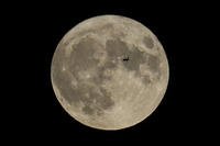 A plane passes in front of the moon