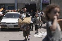 Palestinians evacuate a school that had been their shelter, in Deir al-Balah