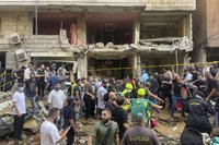 People gather near a damaged building at the scene of an Israeli missile strike.