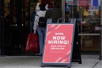 Hiring sign is displayed outside of a retail store