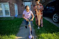 Nicole Bowden watches her daughter Zariah, 7, ride a scooter