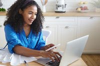 A woman with receipts doing online banking on laptop