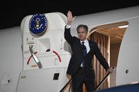 U.S. Secretary of State Antony Blinken waves farewell as he boards his plane.