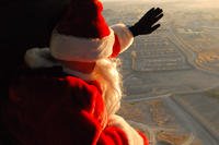 Chief Warrant Officer 2 Brian Boase, dressed as Santa, waves to Forward Operating Base Salerno, Afghanistan, before being dropped off by a UH-60 Black Hawk helicopter.