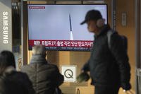 A TV screen shows a report of North Korea's missile launch with file footage during a news program