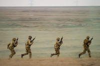 Servicemen run during the Steadfast Dart 2025 exercise