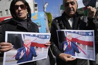 Palestinians carry defaced pictures of U.S. President Donald Trump