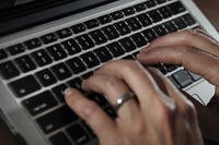 person types on a laptop keyboard in North Andover, Mass.