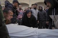 A woman reacts over the body of a person killed during overnight Israeli army airstrikes across the Gaza Strip, at the Al-Ahli hospital in Gaza City