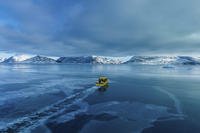 A boat rides though a frozen sea inlet outside of Nuuk, Greenland.