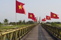 Vietnamese flags fly on the Hien Luong Bridge, with a memorial in the distance, at the former border between North and South Vietnam