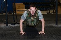 U.S. Navy Cmdr. Jeff Dee, commanding officer of Naval Operations Support Center at Offutt Air Force Base Neb., performs a weight-vest push-up inside the Offutt Air Force Base, Nebraska, Field House gym.