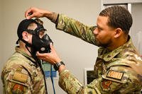 Two airmen from the 90th Medical Group bioenvironmental engineering office practice a gas-mask fitting at F.E. Warren Air Force Base, Wyoming.
